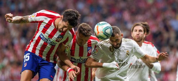 Benzema lucha por un balón en el derbi contra el Atlético