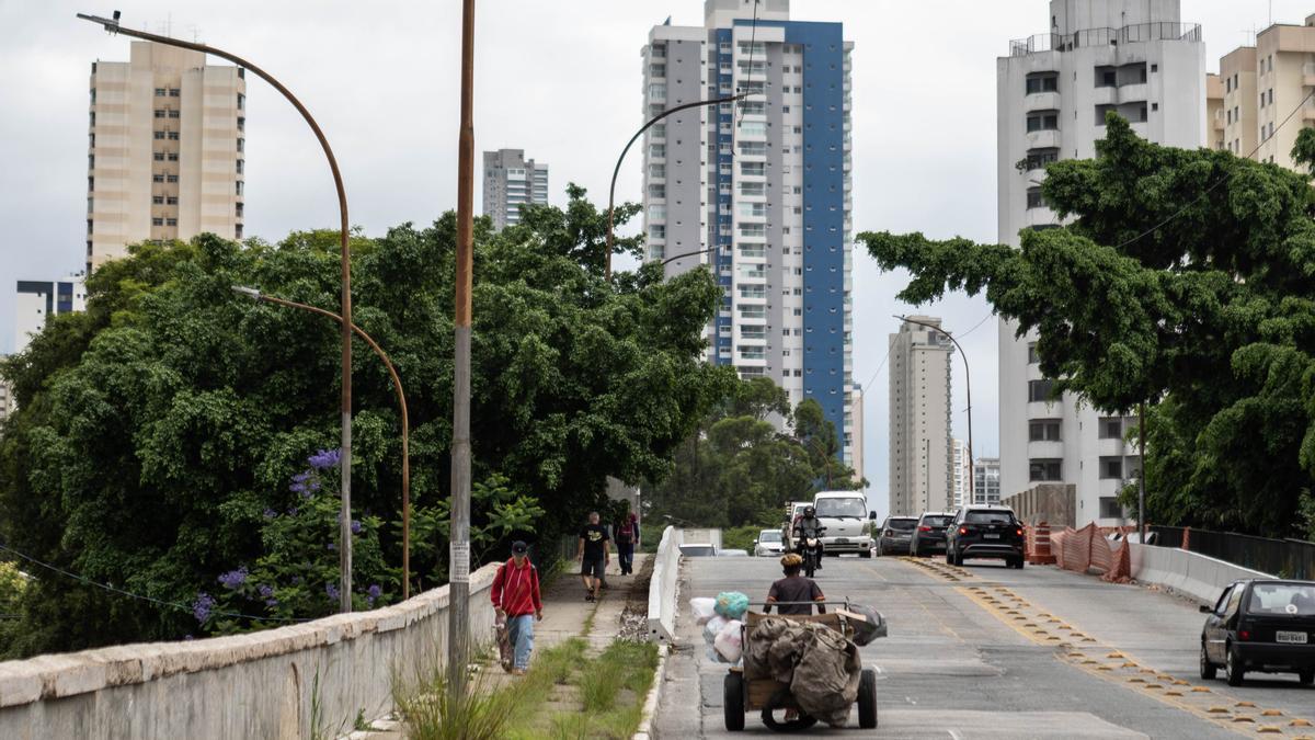 Un hombre arrastra una carreta donde recoge basura camino a uno de los barrios residenciales de clase media de Sao Paulo.