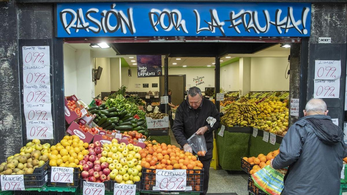 Un par de clientes compran en una frutería de Vitoria.