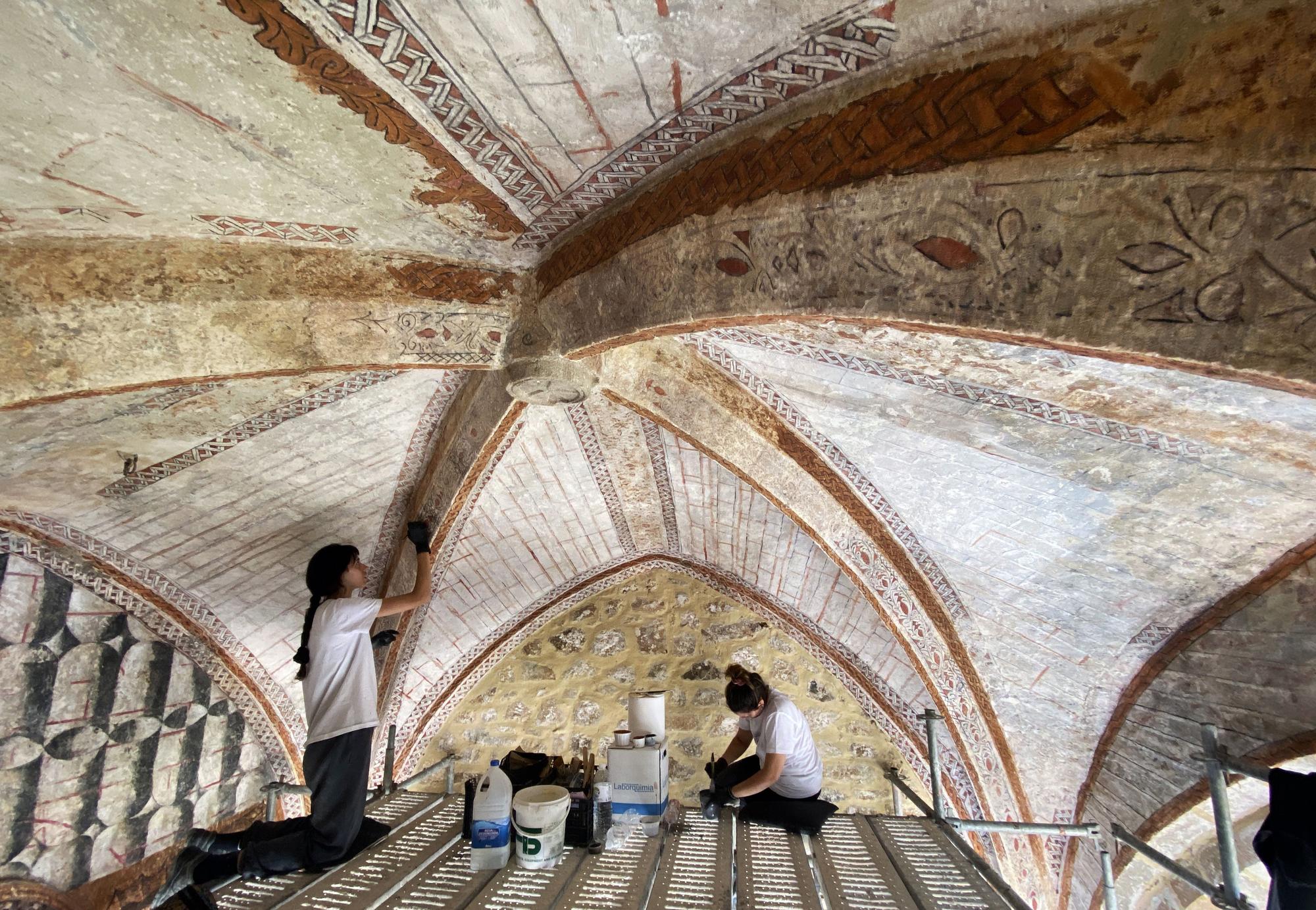 Dos restauradoras trabajan en la recuperación de la capilla del cementerio de Ojedo, en Cillorigo de Liébana