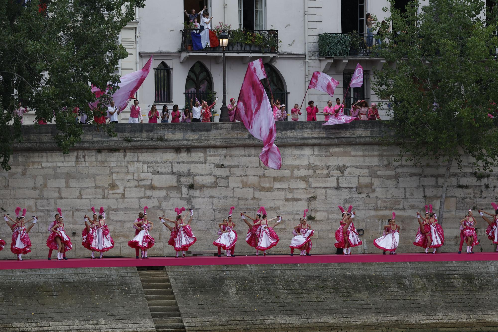 Varios artistas bailan el cancán a orillas del río Sena al paso de la selecciones olímpicas durante la ceremonia de inauguración de los Juegos Olímpicos de París 2024, este viernes en la capital francesa.