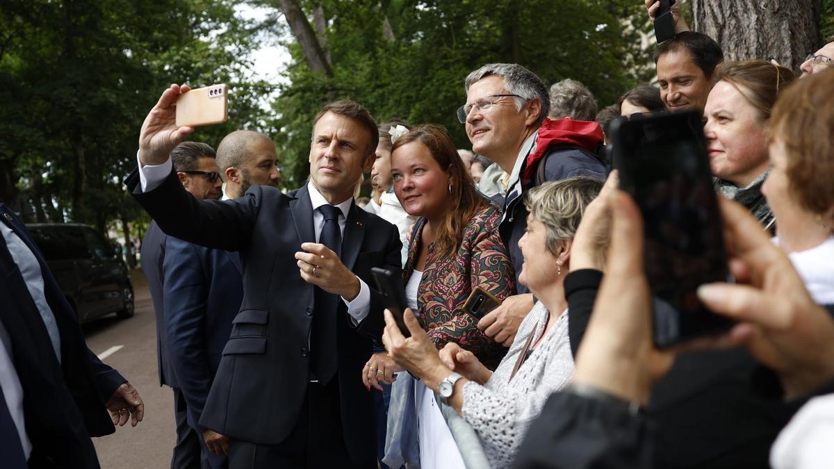 El presidente francés, Emmanuel Macron, saluda a sus partidarios después de emitir su voto en la segunda vuelta de las elecciones parlamentarias francesas en un colegio electoral en Le Touquet-Paris-Plage, norte de Francia.