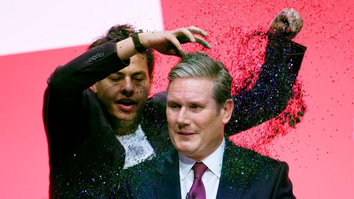 Keir Starmer en el congreso del Partido Laborista mientras un hombre protesta arrojándole purpurina, en Liverpool en septiembre de 2023.