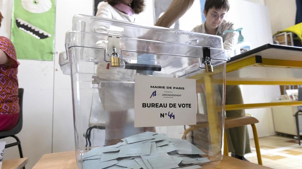 Una persona deposita su voto en la segunda vuelta de las elecciones parlamentarias francesas en una mesa electoral en el Distrito 18 de París, Francia, 07 de julio de 2024