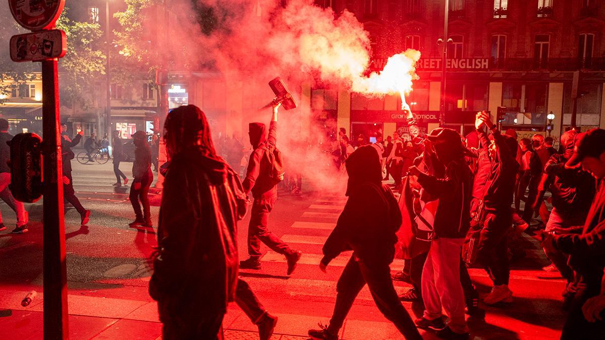 Un grupo de asistentes a la manifestación en la Plaza de la República encienden bengalas.