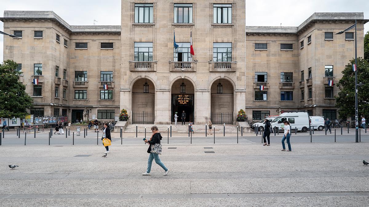 Una mujer camina frente al ayuntamiento de Montreuil, a las afueras de París.