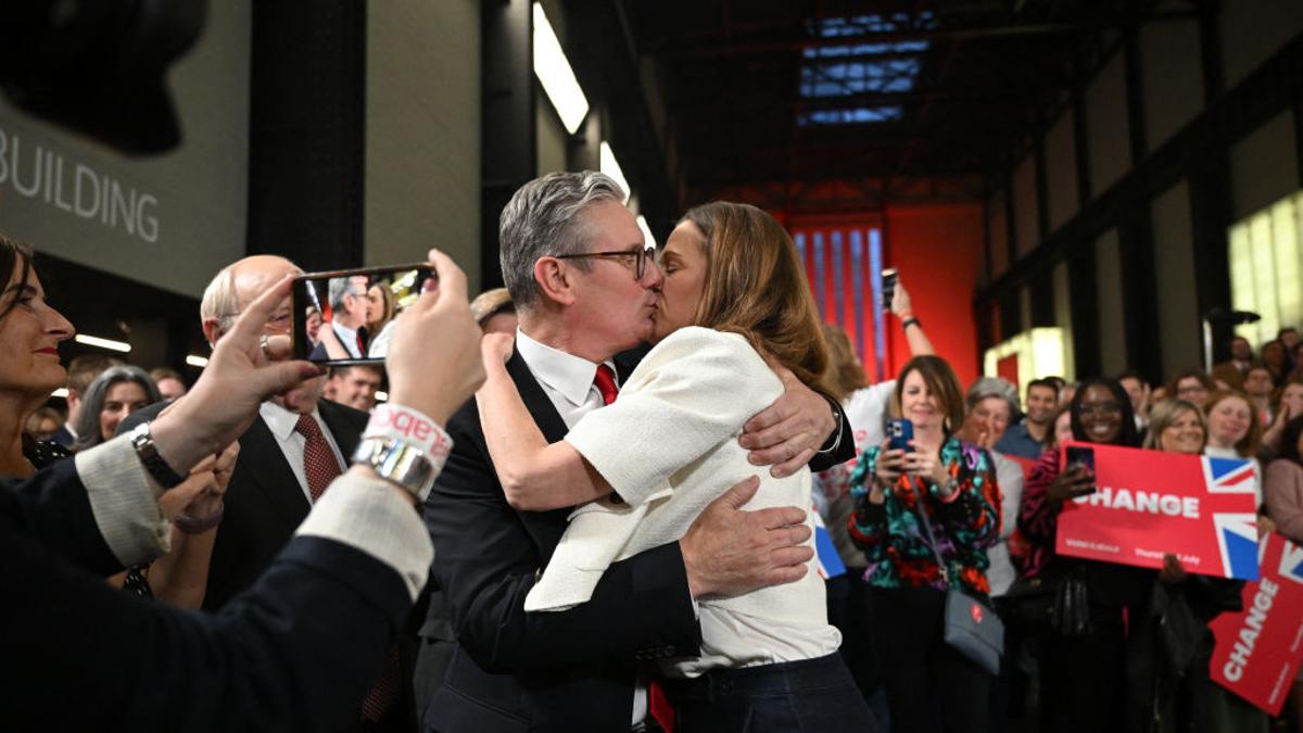 El líder laborista, Keir Starmer, besa a su esposa, Victoria, tras el discurso de la victoria en las elecciones generales en la Tate Modern de Londres, este viernes al amanecer.