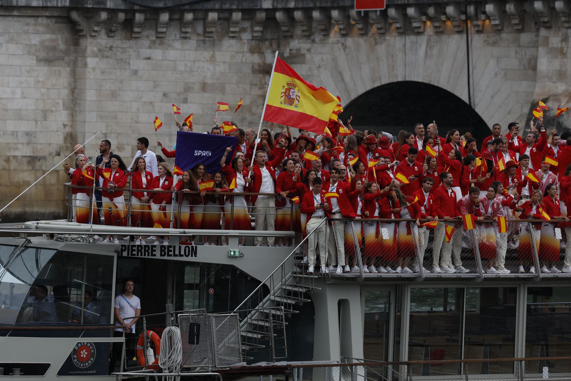 PARÍS (FRANCIA), 26/07/2024.- Miembros de la delegación española desfilan en barco por el río Sena, durante la ceremonia de inauguración de los Juegos Olímpicos de París 2024, este viernes en la capital francesa.