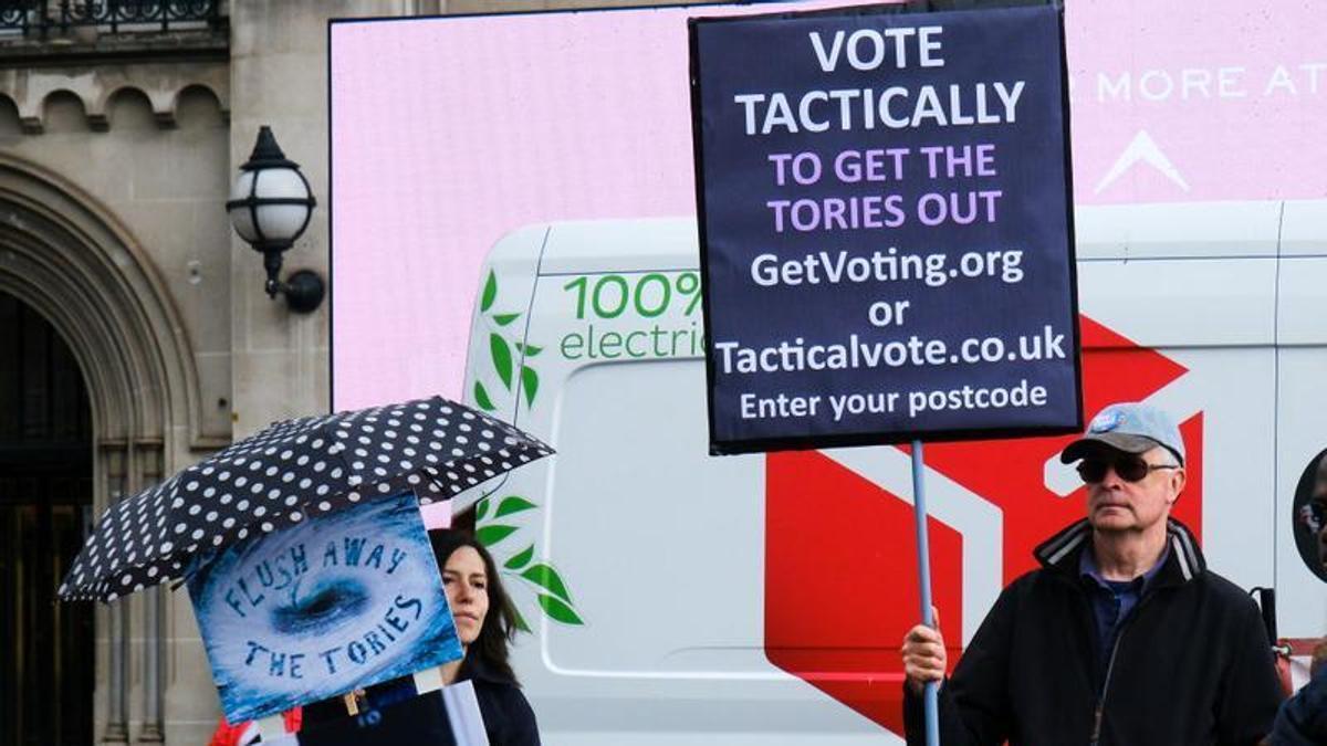 Un hombre sujeta una pancarta animando a votar de manera "táctica" contra el Partido Conservador durante un protesta el 12 de junio, en Londres.