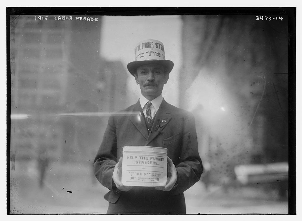 Un hombre recolecta dinero para los huelguistas en el desfile del Día de los Trabajadores de 1915