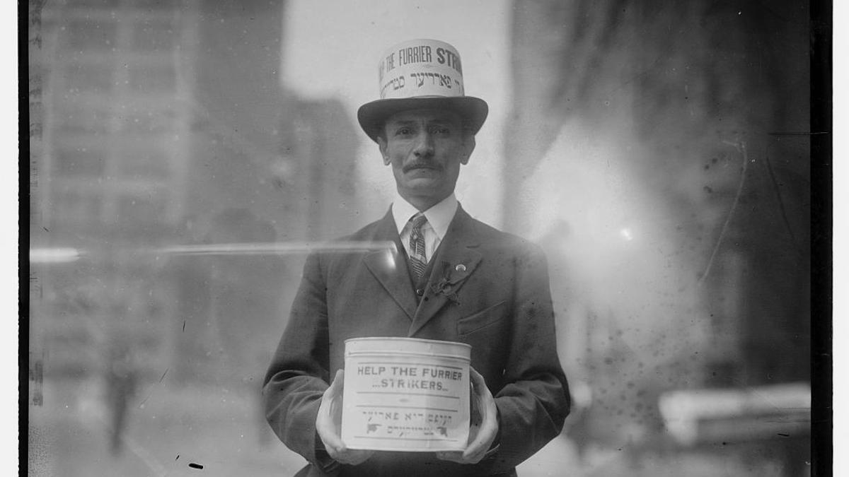 Un hombre recolecta dinero para los huelguistas en el desfile del Día de los Trabajadores de 1915