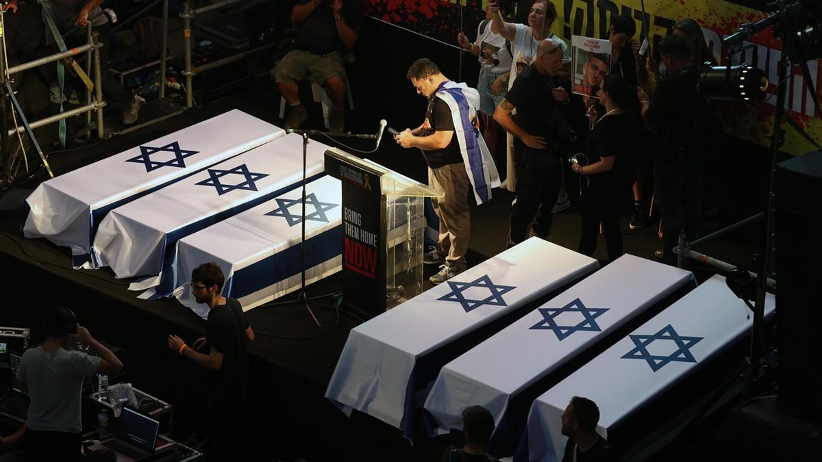 Un escenario de la protesta organizada por los familiares de los rehenes en Tel Aviv con seis ataúdes con la bandera de Israel.