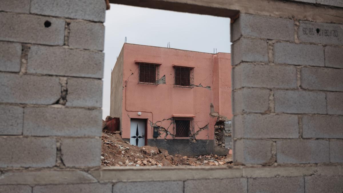 Uno de los edificios que sobrevivió al seísmo en Tafeghaghte frente a una de las nuevas reconstrucciones