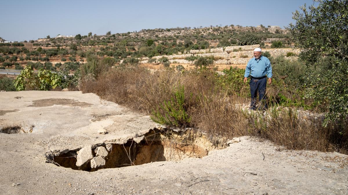 Un agricultor palestino de la localidad de Sinjil observa los daños ocasionados por colonos en su pozo de agua, en septiembre de 2023.