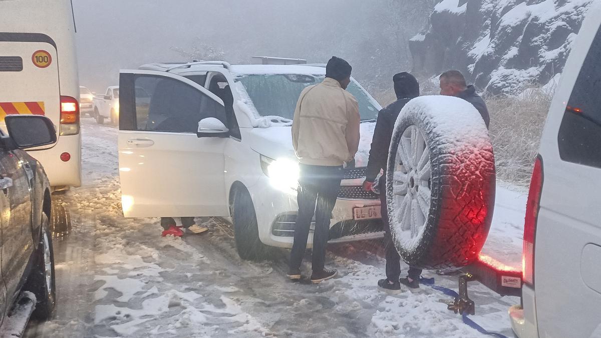 Un grupo de personas intentan liberar a su coche atrapado en una carretera por la nieve el pasado 20 de septiembre