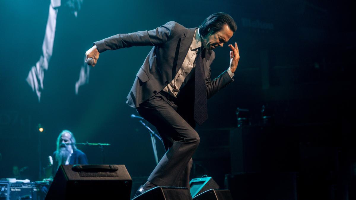 Nick Cave durante su concierto en el WiZink Center. A la izquierda, al fondo, Warren Ellis