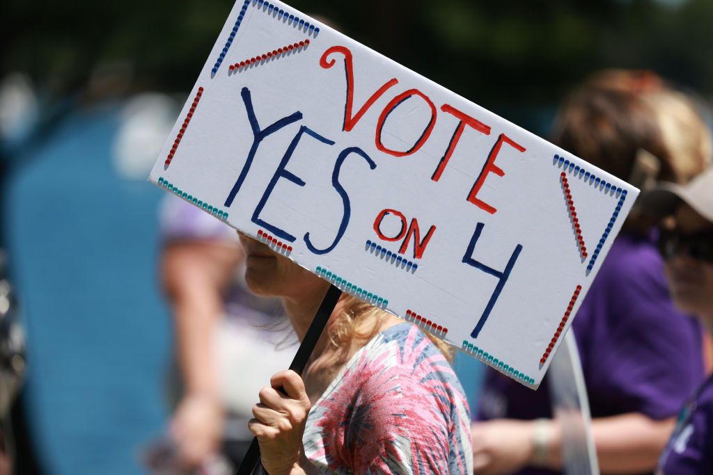 Una manifestante pide el voto a favor de la enmienda para eliminar la prohibición del aborto a partir de la semana sexta de gestación en Florida.