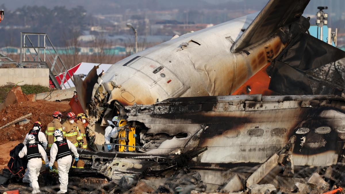 Bomberos y equipos de rescate buscan entre los escombros del accidente en Muan