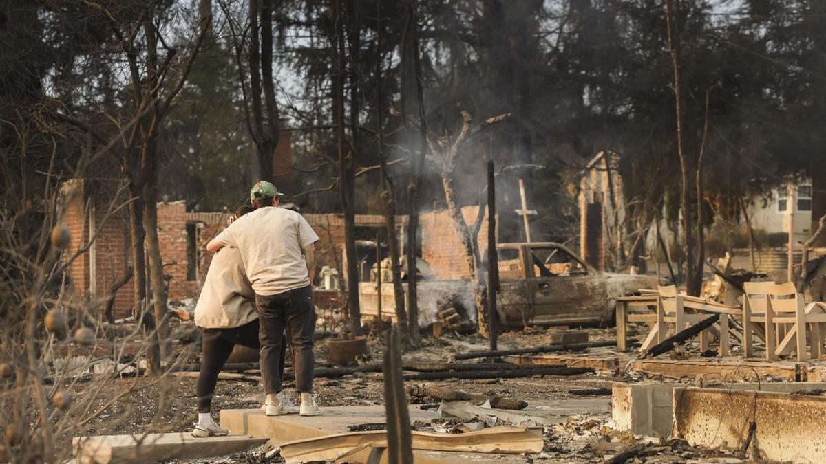 Dos personas contemplan los restos de las casas incendiadas en Altadena (Los Ángeles).