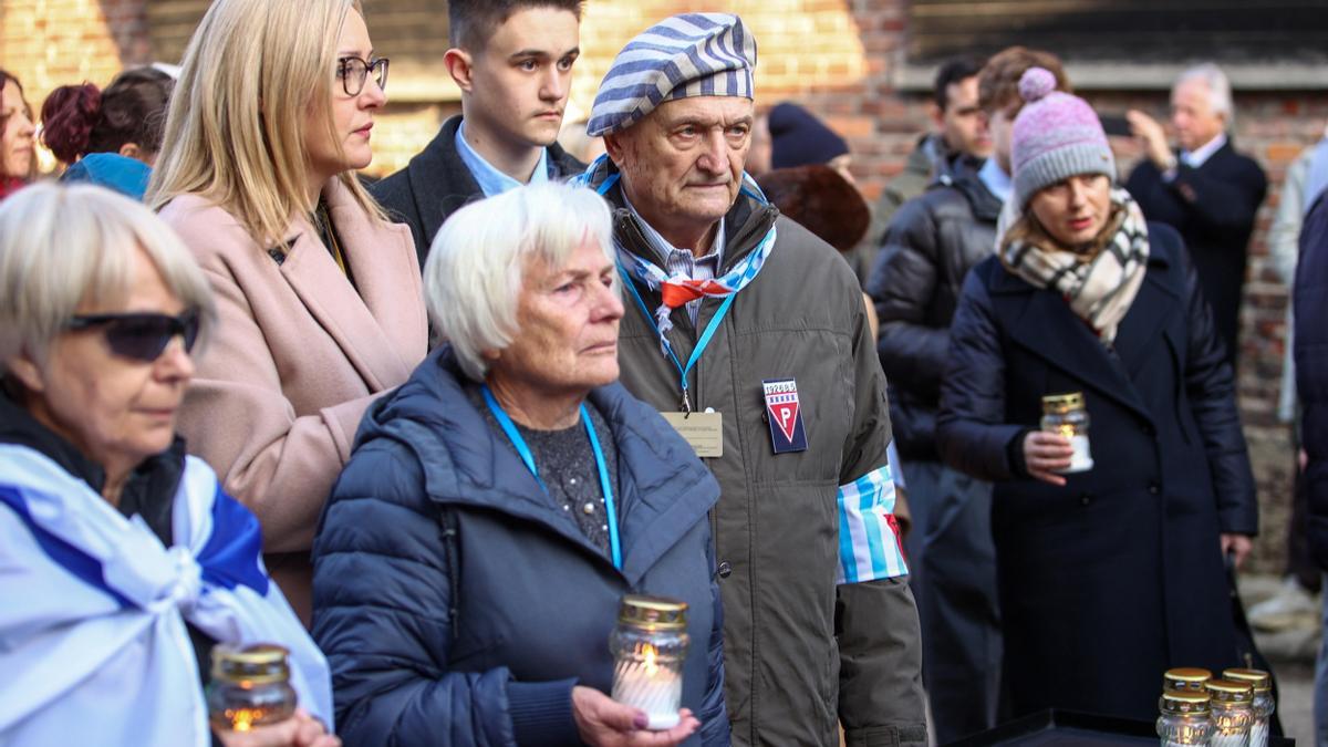 Supervivientes del campo de concentración y de exterminio nazi de Auschwitz y sus familiares encienden velas frente al emblemático 