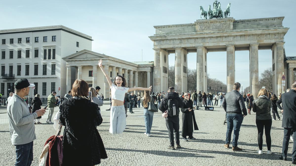 Una mujer se hace una foto en la turística Puerta de Brandeburgo.