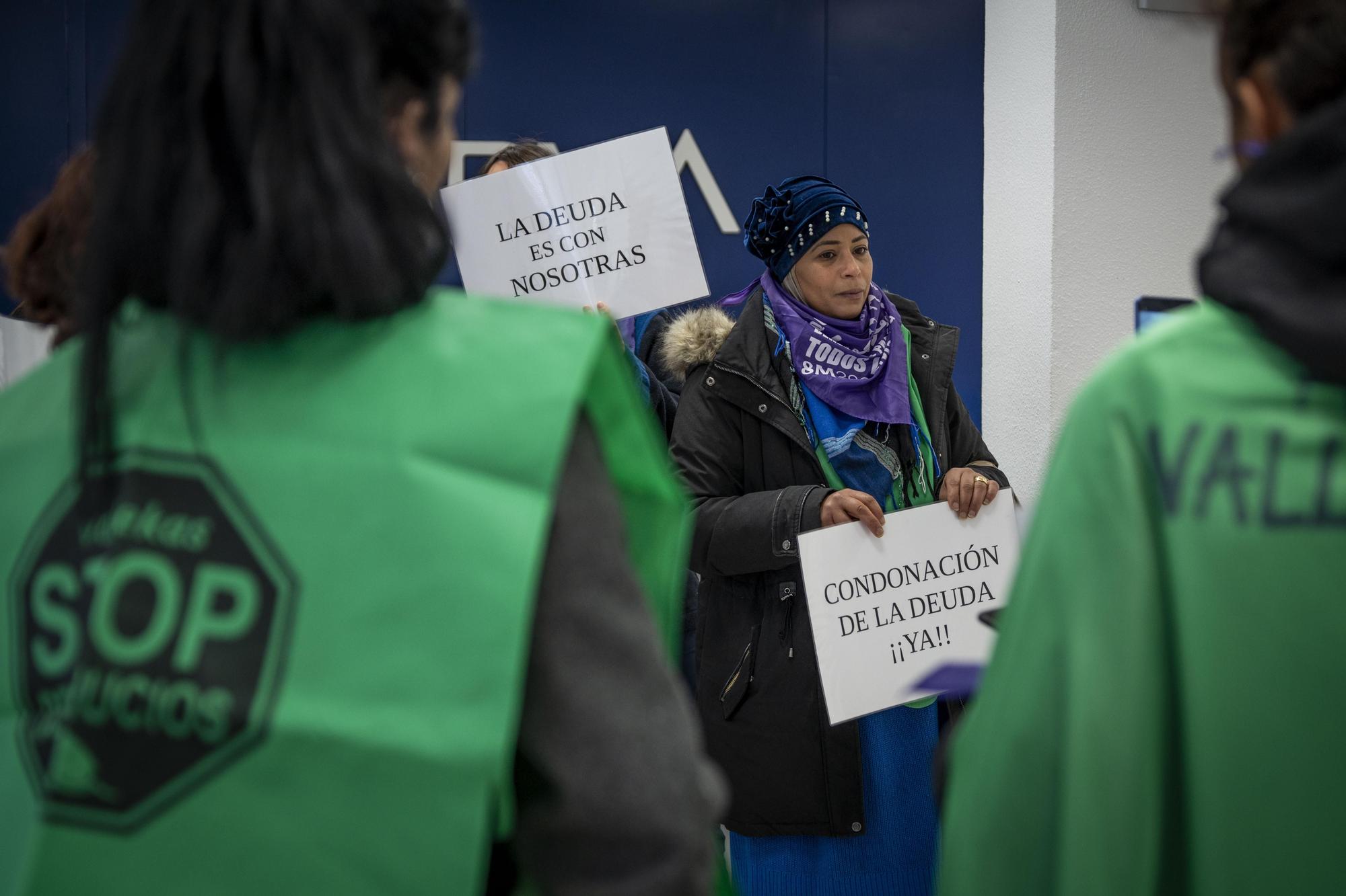 Un grupo de activistas acompaña a Ghita a la oficina bancaria donde firmó la hipoteca hace 19 años para reclamar la condonación de la deuda que arrastra desde que la entidad se quedó con la vivienda tras la crisis financiera