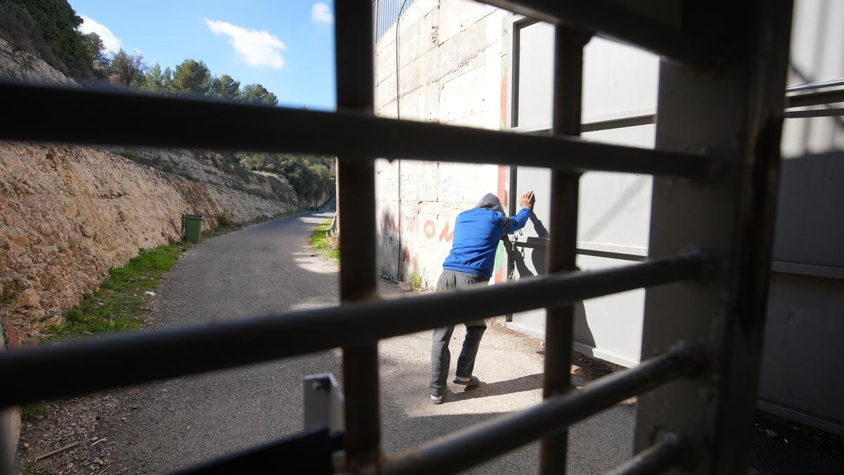 Omar Hajajleh abre la puerta metálica para atravesar el túnel que da acceso a su casa.