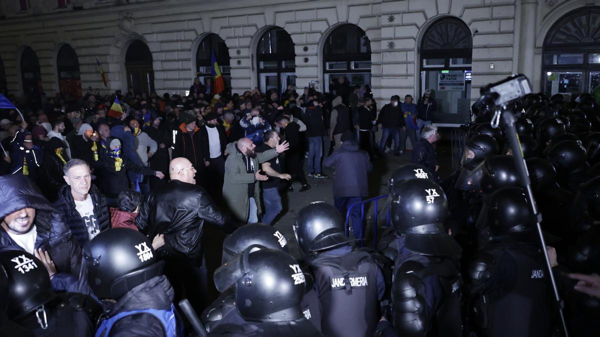 Partidarios del ultranacionalista Calin Georgescu discuten con policías antidisturbios durante una protesta el 9 de marzo que se volvió violenta frente a la Oficina Electoral Central 